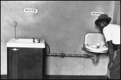USA. North Carolina. Segregated water fountains with black man drinking water.